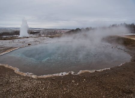 Boiling thermal water with the Great Geyser in the backgroundの写真素材
