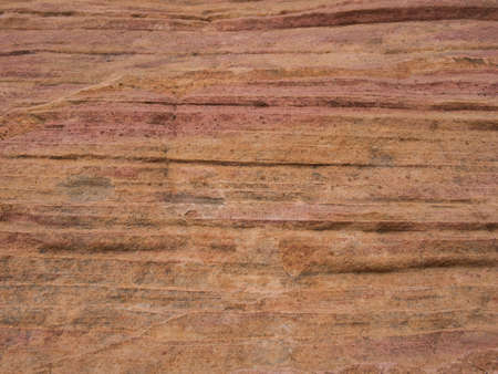 A rock face with colourful lines and sandy but very hard surfaceの写真素材