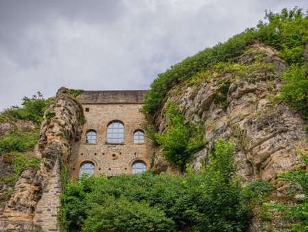 An old stone house facade with window between two rocksの写真素材