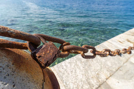 A rusted chain and an old rusty lock on a boardwalkの写真素材