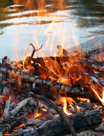 Outdoor fire burning near a lakefrontの写真素材
