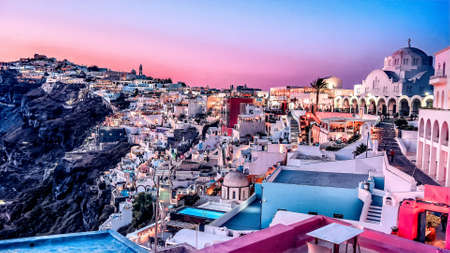 Sunset in Oia town, Santorini island, Greece. Traditional and famous white houses and churches with blue domes over the Caldera, Aegean seaの写真素材