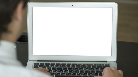 Closeup of businessman typing on laptop with blank screen. Mock up.の写真素材