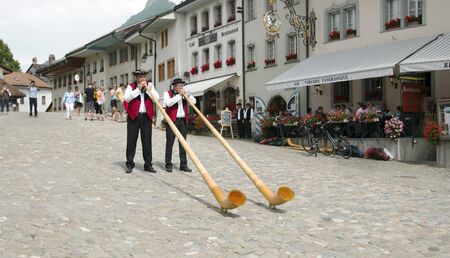 Gruyere, Switzerland - July 19, 2014. Swiss musicians play the folk national musical instrument alphorn in the Gruyere village.のeditorial素材