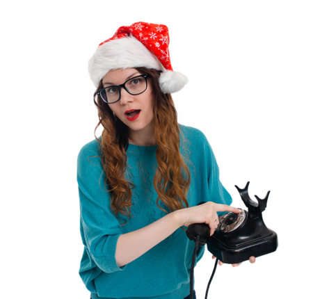 Beautiful girl in Santas hat with old phone on white backgroundの写真素材