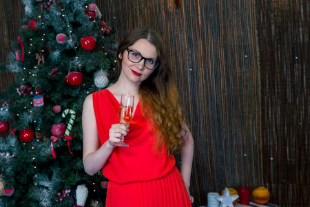 Beautiful girl with red dress and glass of wineの写真素材
