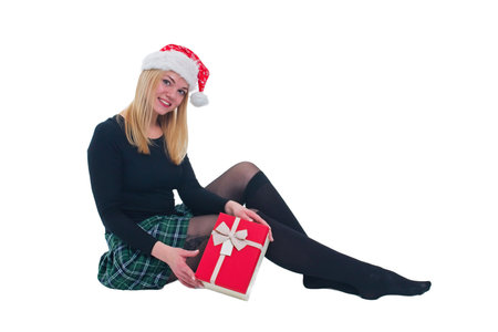 woman sitting with christmas hat and present in isolated backgroundの写真素材