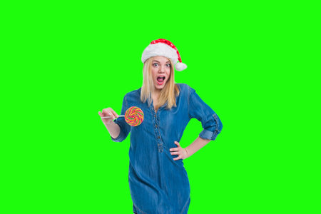 santa hat woman holding a lollipop in green screenの写真素材