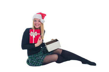 woman sitting with christmas hat and present in isolated backgroundの写真素材