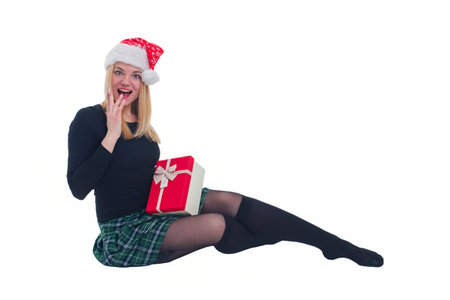 woman sitting with christmas hat and present in isolated backgroundの写真素材