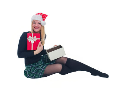 woman sitting with christmas hat and present in isolated backgroundの写真素材