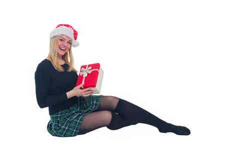 woman sitting with christmas hat and present in isolated backgroundの写真素材