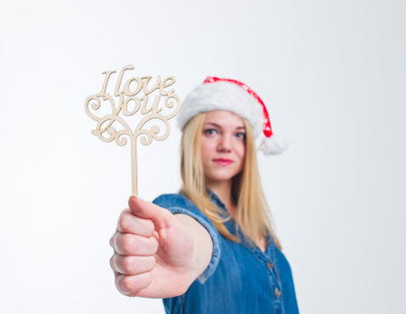 santa hat woman holding I Love You sign in white screenの写真素材
