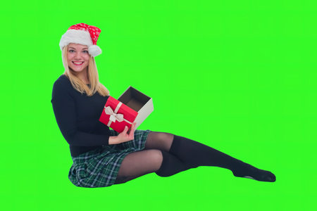 woman sitting with christmas hat and present in isolated backgroundの写真素材