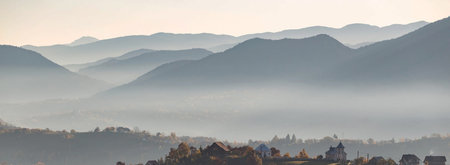 Panoramic view of the mountains in the fog at sunrise.の写真素材
