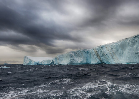 Antarctic icebergs in the ocean with stormy sky.