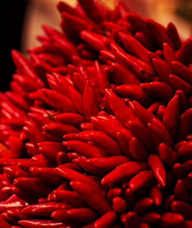 Close up of red chili peppers for sale at a market stall.