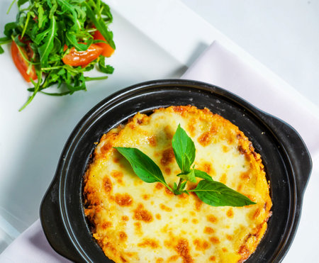 Potato pancake with cheese and arugula on white plateの写真素材