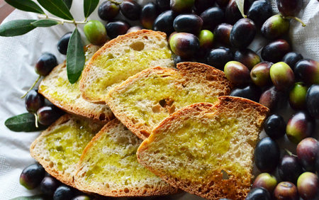Olive bread with olive oil and fresh olives on the table