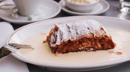 Apple strudel with icing sugar on a white plate in a cafeの写真素材