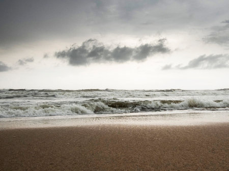 Stormy Baltic sea with waves and foam on sandy beach, Latvia.の写真素材