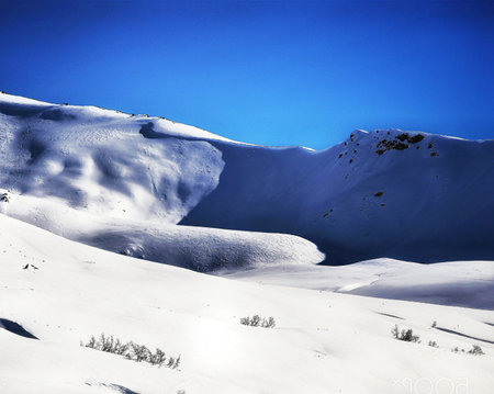 Beautiful winter landscape with snow-capped mountains and blue sky