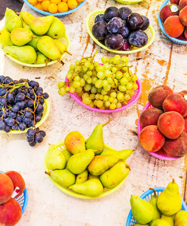 Colorful fruit plums, pears, grapes and plums on a rustic wooden table