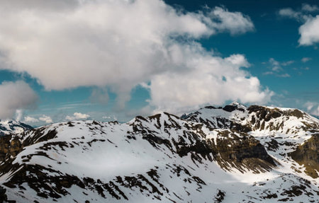 Mountain landscape. Snowy mountains and blue sky with clouds.の写真素材