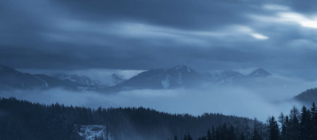 Panoramic view of the mountains in the fog. Winter landscape.の写真素材