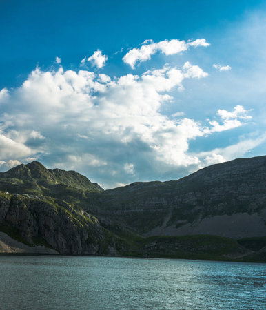 Lake in the mountains under the blue sky with clouds. Landscape.の写真素材