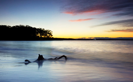 Silhouette of a man swimming in the sea at sunset.の写真素材
