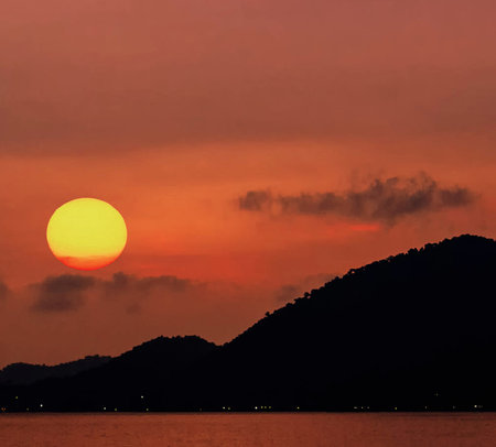 Beautiful sunset on the sea and mountain at Phuket Thailandの写真素材