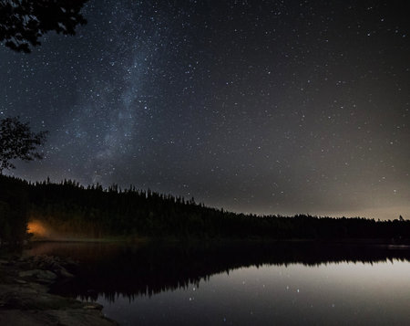 Milky way over the lake in the forest. Long exposure.の写真素材