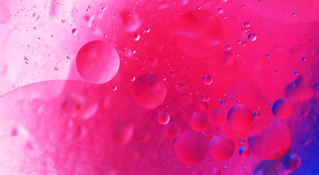 bright oily drops in water with colorful background, close-up shot