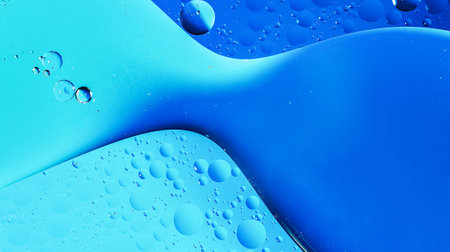 Oil drops on water surface with colorful background, close-up.