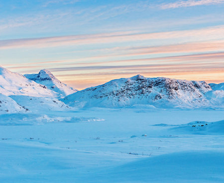 Beautiful winter landscape with snow covered mountains and blue sky at sunsetの写真素材