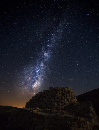 Milky Way over the ruins of an ancient fortress in the mountains