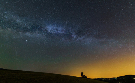 Milky Way galaxy with silhouette of a man on the hill.の写真素材