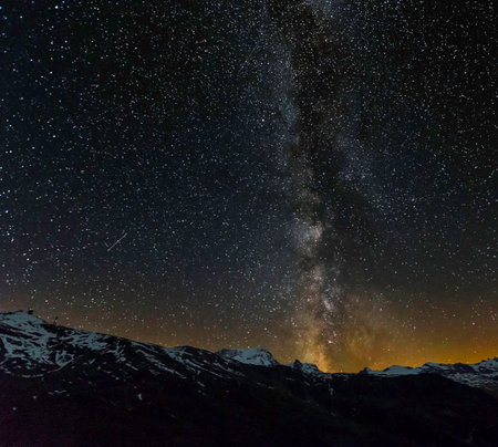 Milky way and stars in the night sky over the mountains.の写真素材