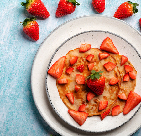 Pancakes with strawberries and honey on a blue background. Selective focus.の写真素材