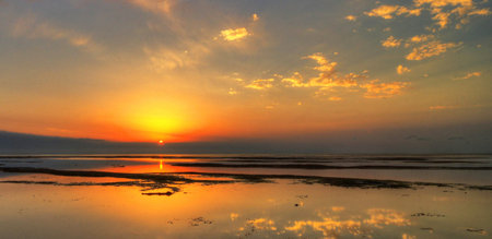 Beautiful sunset at the beach with reflection in water, Thailand.