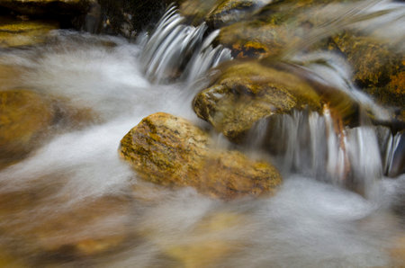 Mountain stream flowing through the rocks. Long exposure. Motion blur.