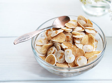 Pancakes in a glass bowl on a white wooden background.の写真素材
