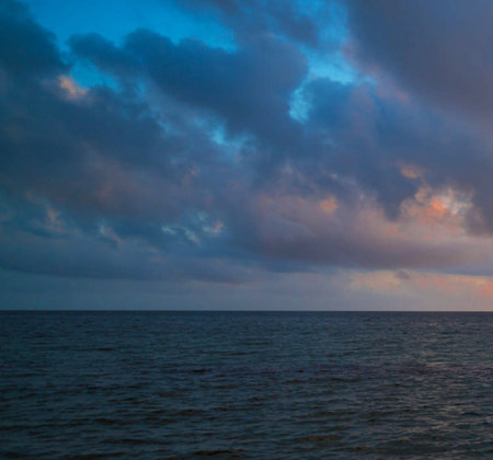 Beautiful sunset on the sea. Dramatic sky with clouds.の写真素材