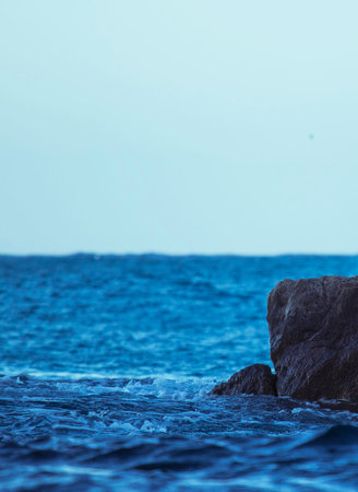 beautiful seascape with rocks and sea waves in the eveningの写真素材