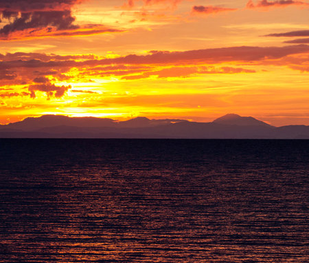 Beautiful sunset over the sea with mountains in the background. Toned.の写真素材