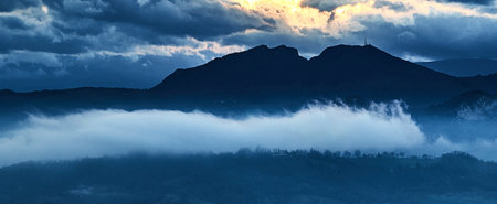 Panoramic view of the mountains in the fog at dawn.