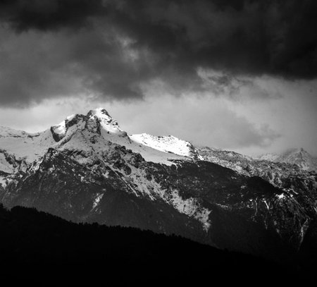 Black and white image of snow capped alpine peaks in Switzerland.