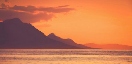 Sunset over the sea with mountains in the background. Toned.の写真素材