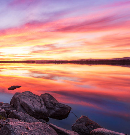 Beautiful sunset on the lake. Colorful sky reflected in water.の写真素材